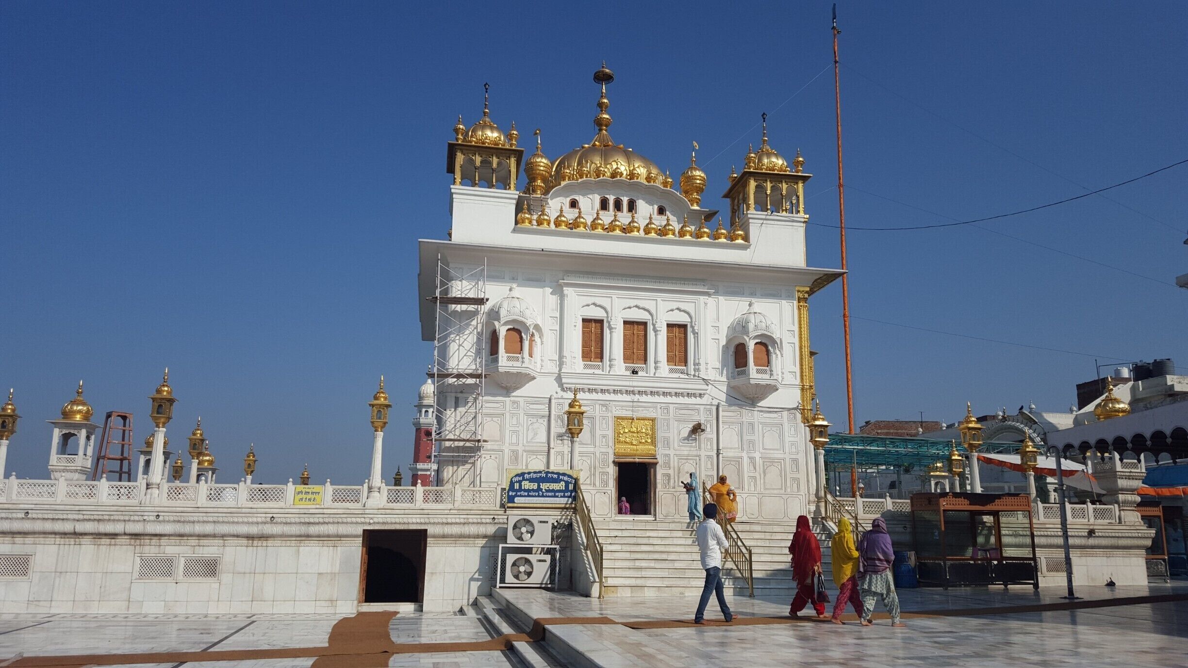 A white building with golden domes and a large entrance.