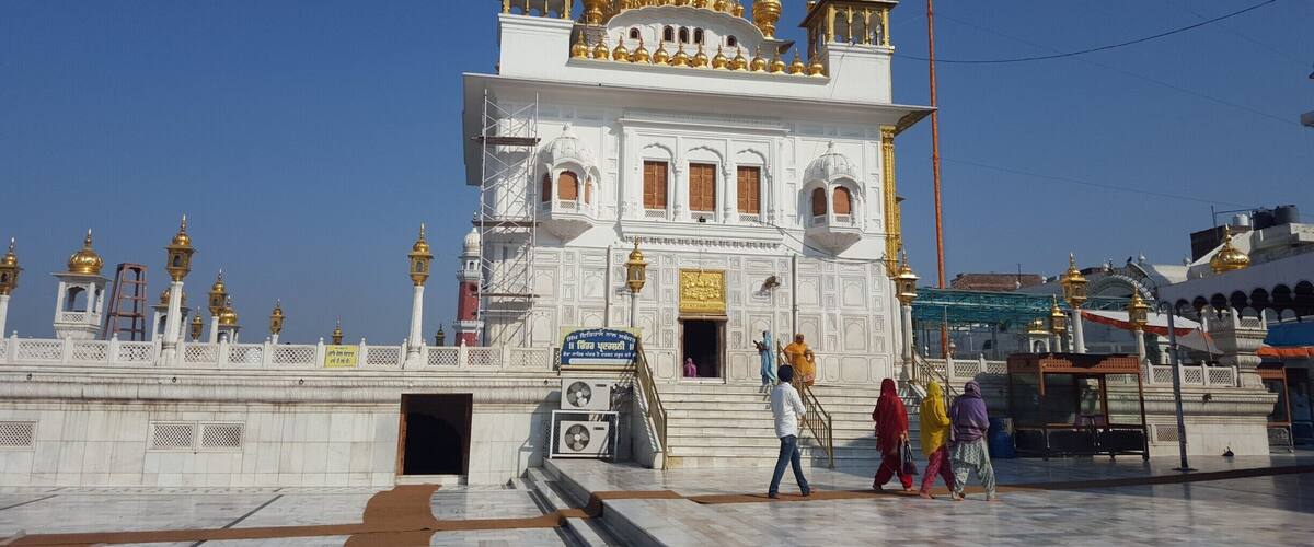 A white building with golden domes and a large entrance.