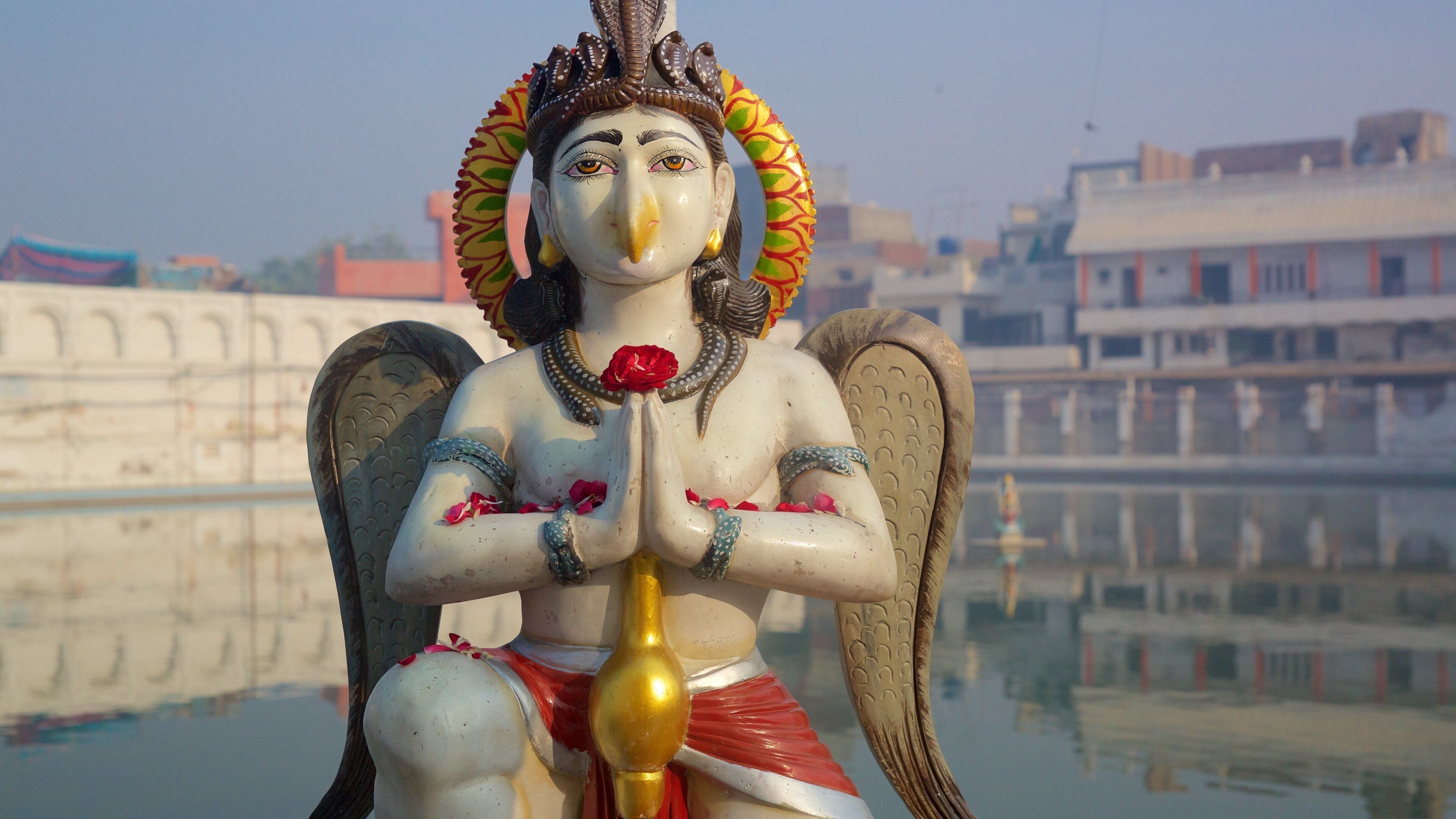 Durgiana Temple featuring a lake or waterhole and a statue or sculpture