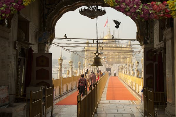 Durgiana Temple showing a temple or place of worship and heritage elements as well as a small group of people