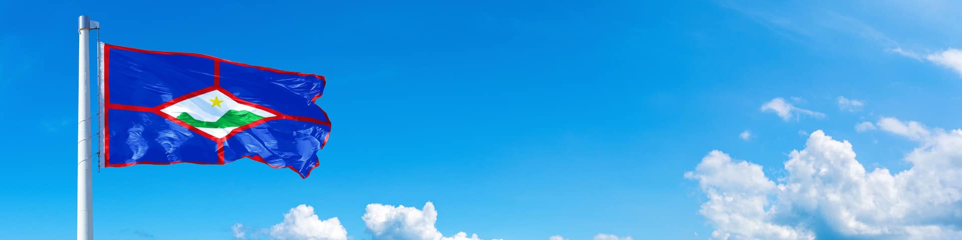 Sint Eustatius flag waving on a blue sky in beautiful clouds - Horizontal banner