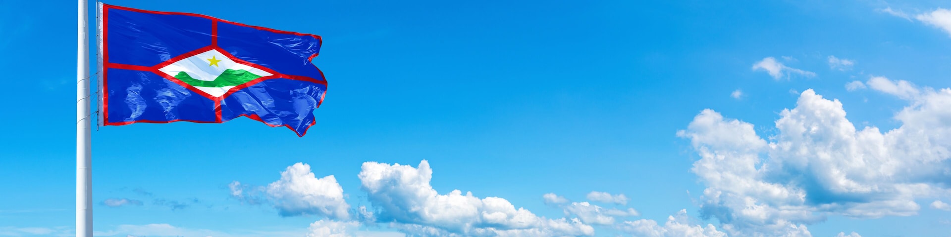 Sint Eustatius flag waving on a blue sky in beautiful clouds - Horizontal banner