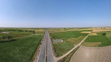 A 180 degree panorama of long road leading to District Narowal of Punjab province. It was captured with a drone amid wheat fields and honey bee farms