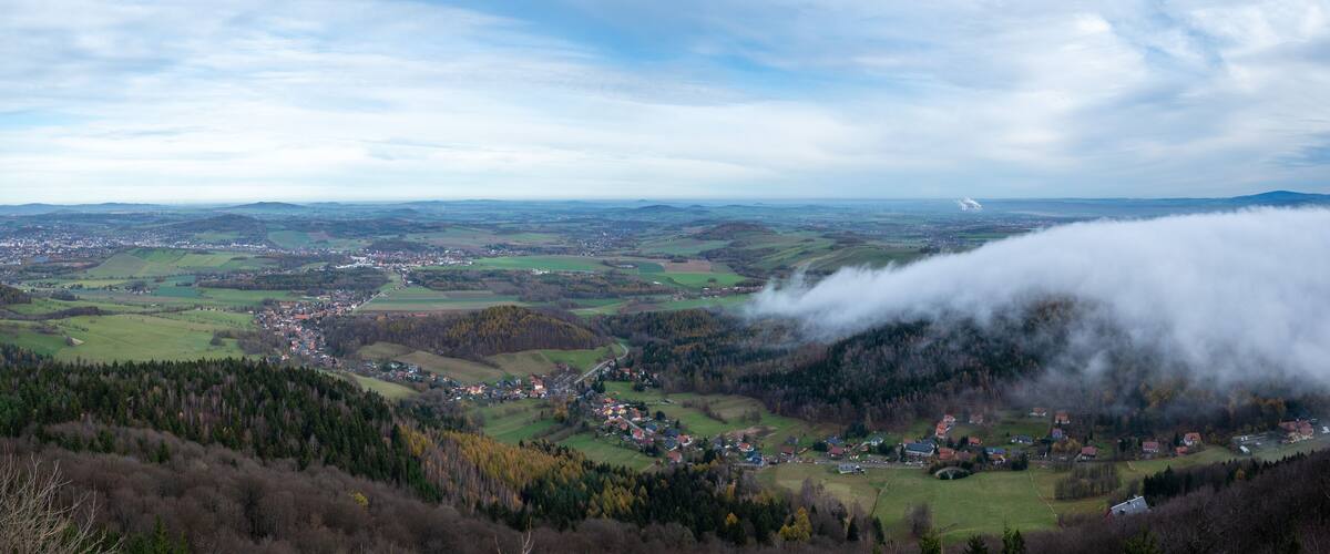 A valley with a small town surrounded by hills and forests.