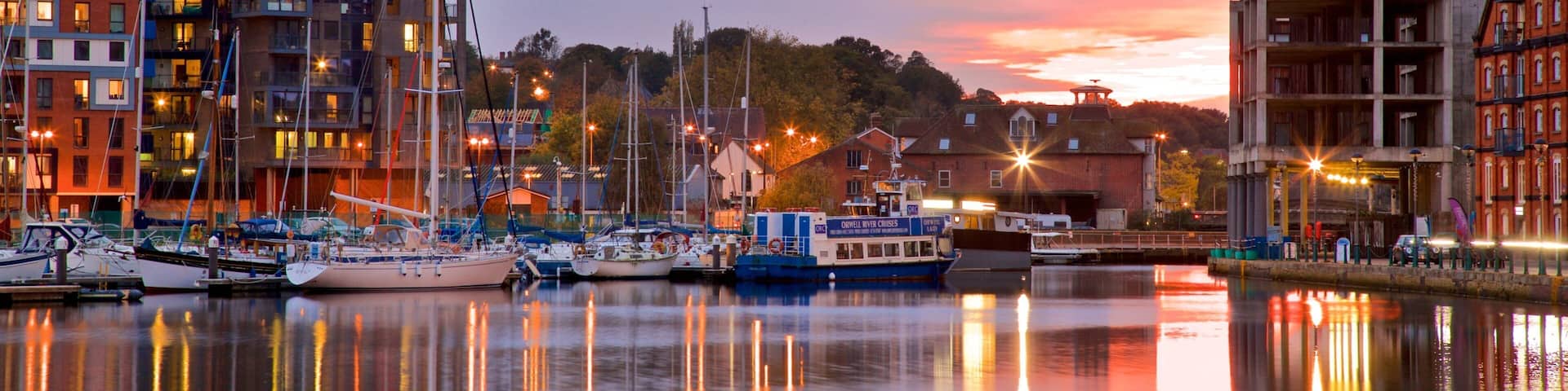 Ipswich Waterfront som visar en hamn eller havsbukt och en solnedgÄng