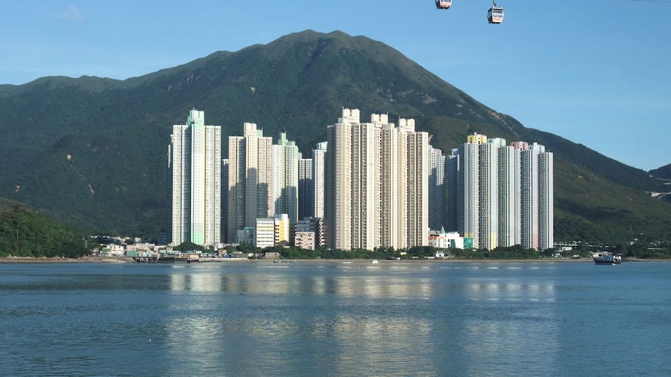 A cityscape with tall buildings and a mountain in the background.