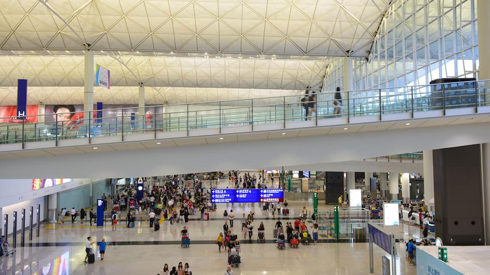 A spacious airport terminal with a high ceiling and glass railings.
