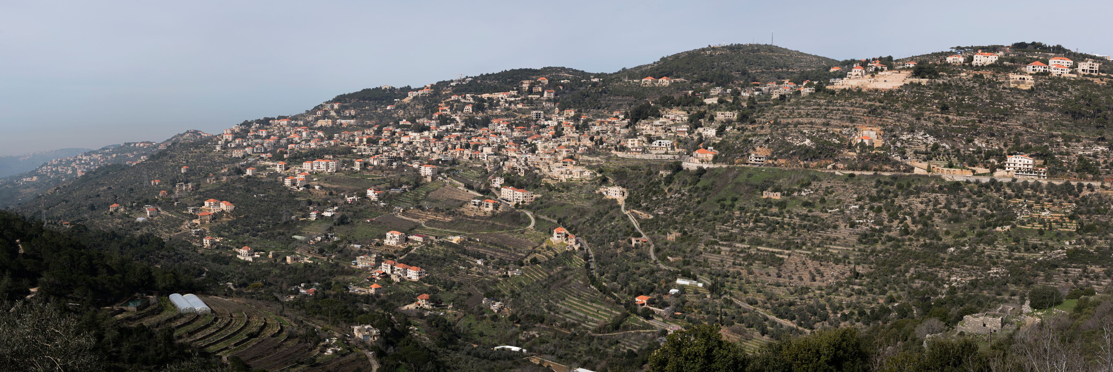 A hillside village with terraced fields and scattered houses.