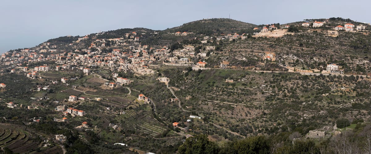 A hillside village with terraced fields and scattered houses.