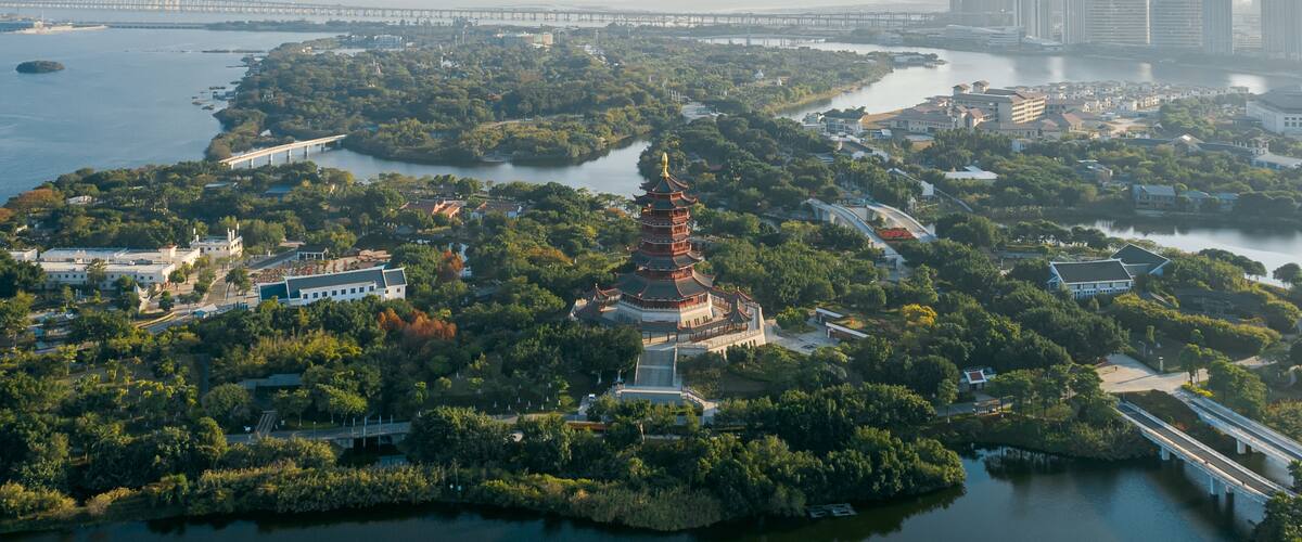 Aerial view of Xiamen Yuanboyuan, Expo garden scenic area with lakes and city skyline at dusk