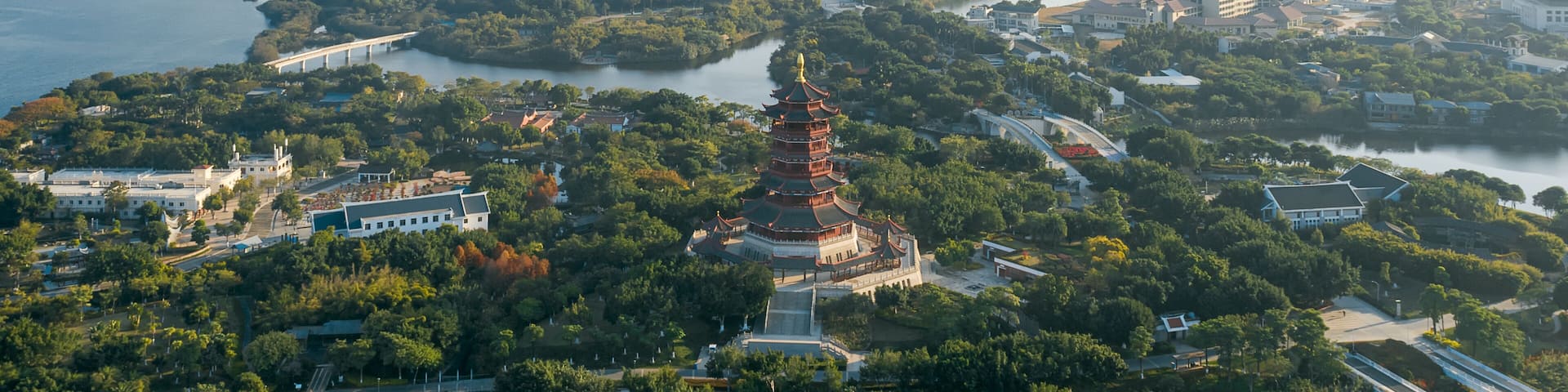 Aerial view of Xiamen Yuanboyuan, Expo garden scenic area with lakes and city skyline at dusk