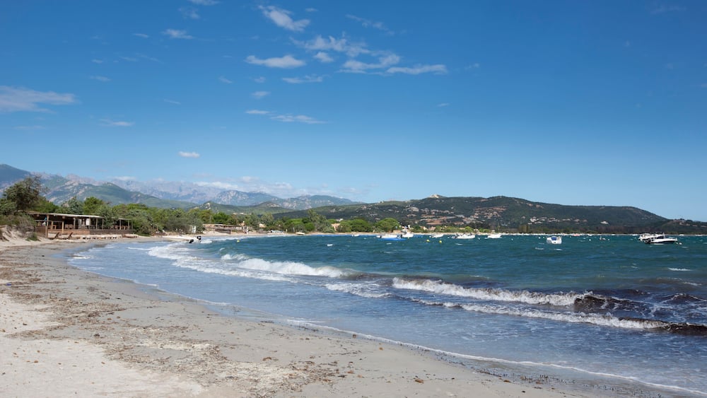 Dramatic view of San Cirprianu Beach in Lecci, Corsica, France on a stormy day with rough seas and waves and a big blue sky with fluffy clouds; Shutterstock ID 1244169700; Purchase Order: -
