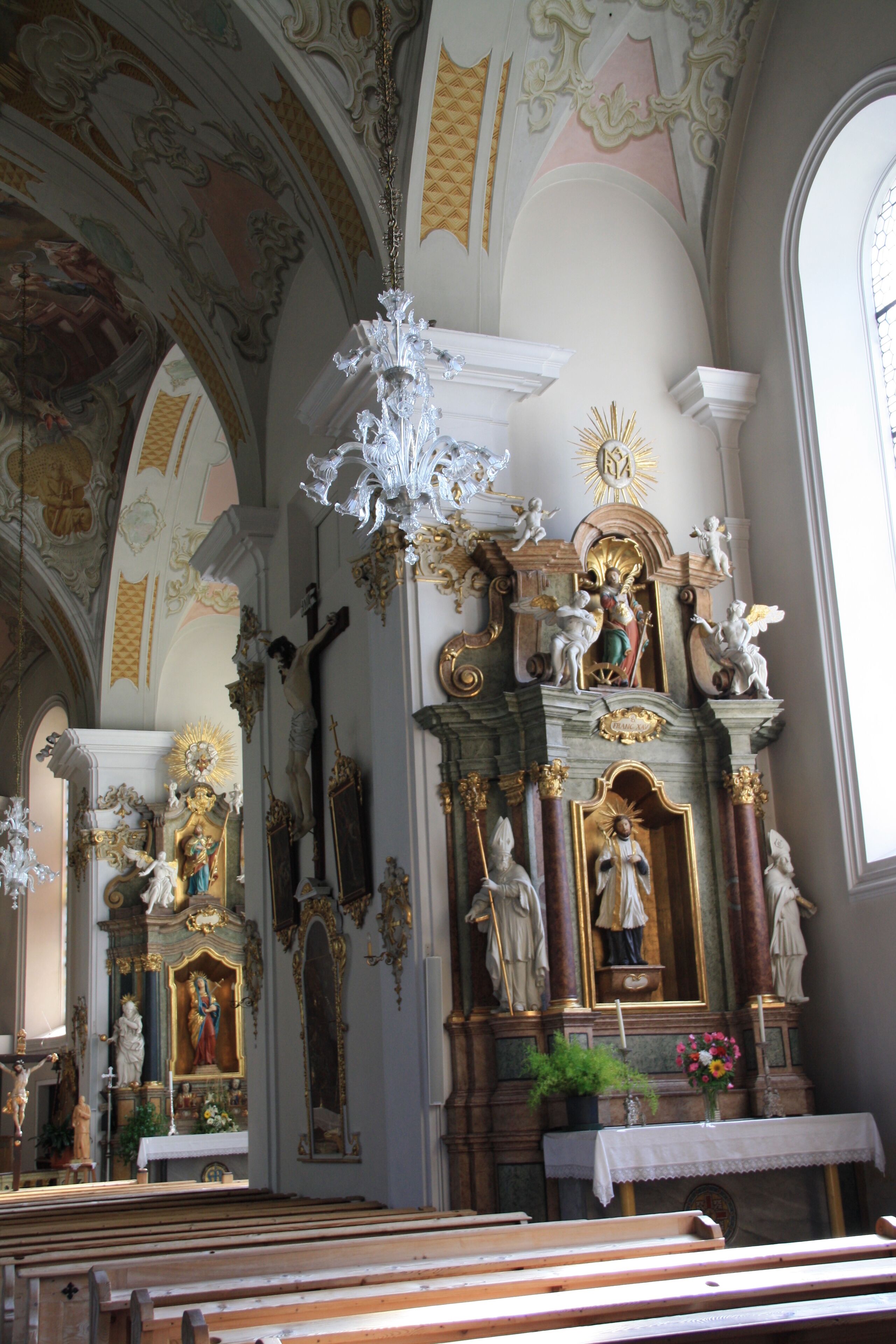 Italy, South Tyrol, Gossensaß. The church is dedicated to the Immaculate Conception and was built in 1750 on the same place of the old gothic church erected in 1471 and dedicated to Saint George of which remains the bell tower. The church was built on design of Franz de Paula Penz in baroque, it is possible a former project by Johann G. D. Grasmair. The church was consecrated on July 4 and 5, 1754 by bishop Leopold von Spaur. The front shows the portal of the old church and the three niches in which are placed the statues of the Immaculate Conception, Joachim and Saint Anne. The nave has a cross shape with two arms forming four lateral chapels. The high altar is rich in golden shades and at the centre of the throne is placed the statute of the Immaculate with the child was installed on April 23, 1752 by Josepf Stapf. The four statues are: St. George, St. Stephen, St. Lawrence and St. Florien. To the left side, between the two lateral chapels, is the baroque pulpit of 1777 positioned in a central site. To the right side between the two lateral chapels is a Crucifix by Bartlmä Kleinhans. The first right lateral altar is dedicated to Our Lady of Sorrows encircled by the statues of Mary Magdalene, Saint Elisabeth and Saint James works of 1750. The second right lateral altar is dedicated to Francis Xavier and two Bishops: Saint Ingenuinus and Saint Albuin coming from the old Saint George church. The first left lateral altar is the Flagellation of Christ at the column and the Saints Peter and John on each side. To the second left lateral altar is Saint Leonard, by side are the statues of Saint Sylvester, Saint Gregory and Saint Barbara coming from the old church. The eastern dome fresco was painted by Matthäus Günther and represents the Christ crowning Mary and Saint George throwing the pierced dragon downwards.