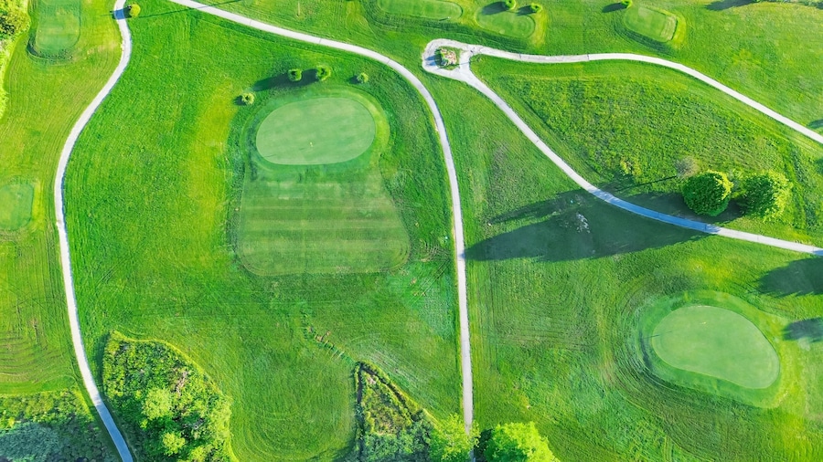 Straight aerial view cart path in 18 holes golf course, lavish greens sloping fairways, lots of trees at municipal country club in Mountain Grove, Missouri, scenic grassy lawn meadow laid back