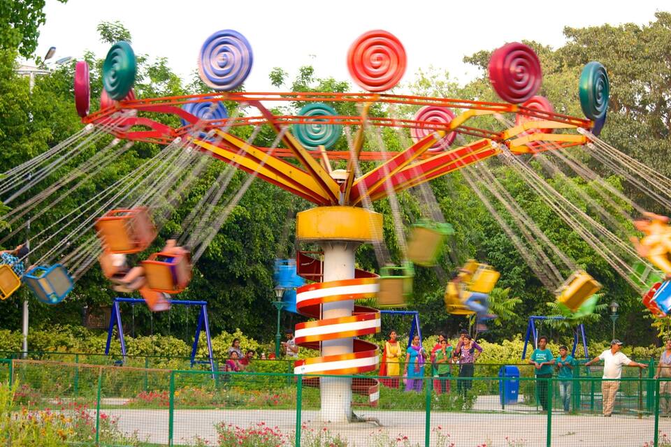 A colorful amusement ride with spinning seats and a central pole.