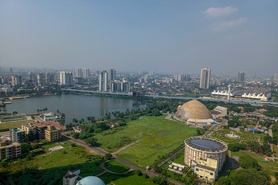 A cityscape with a river, a large dome-shaped building, and a stadium.