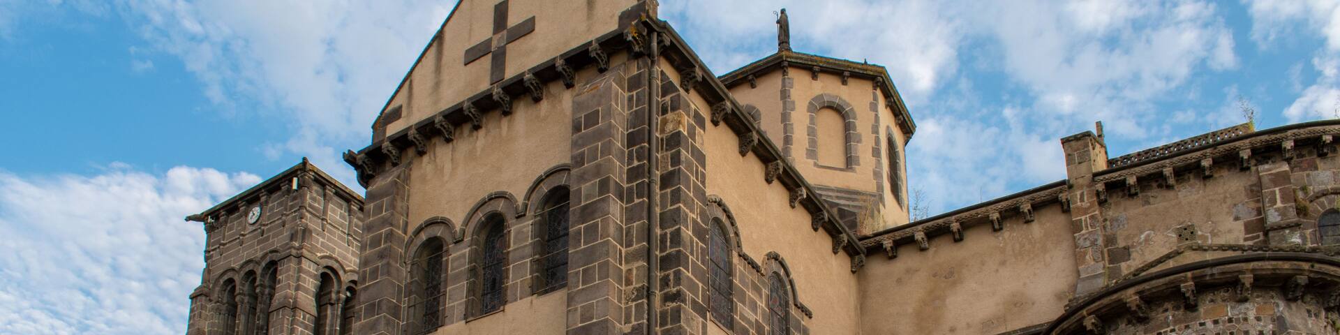 A historic church with a prominent cross on the facade, arched windows, and a bell tower.