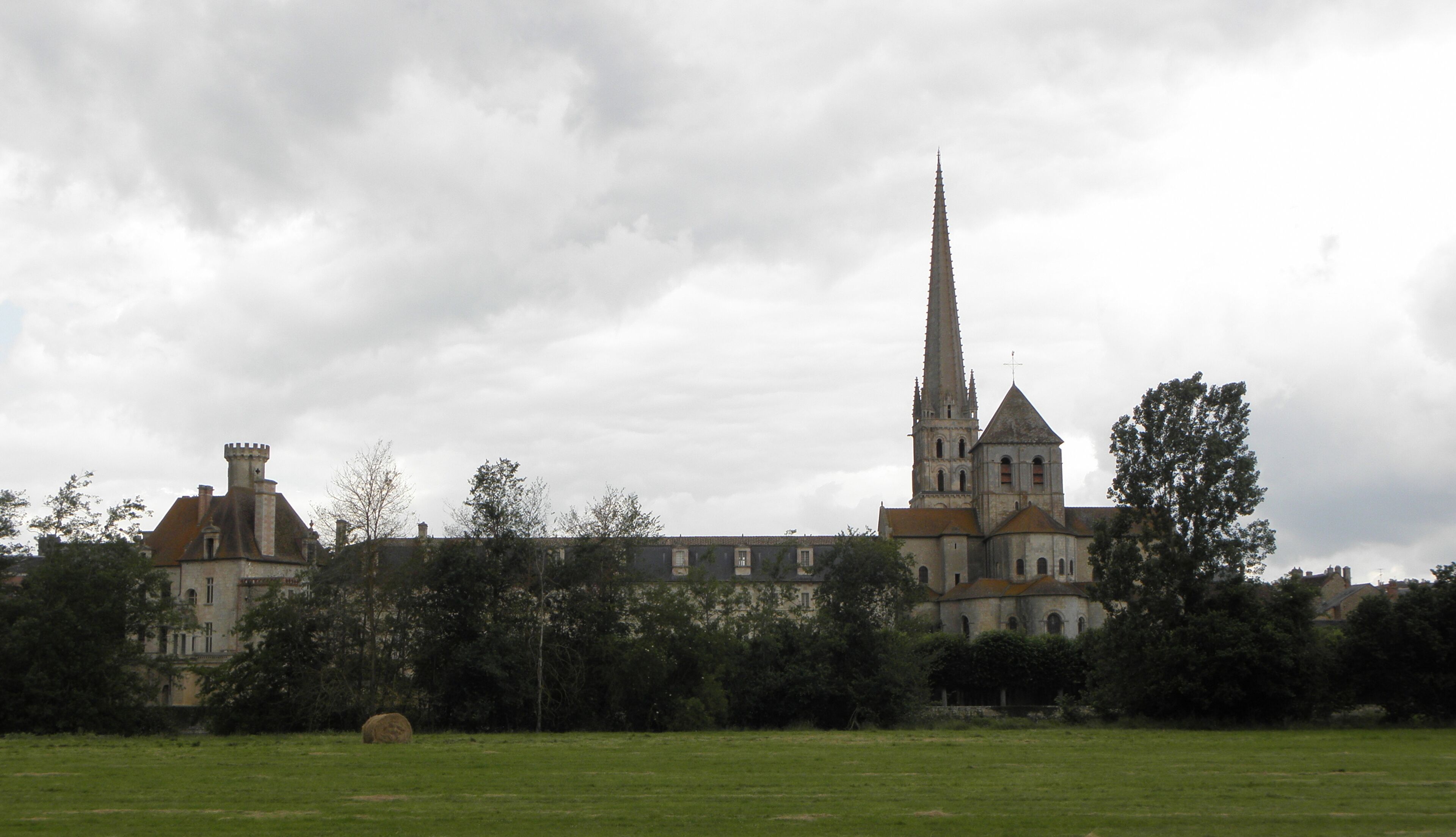 A historic church with a tall spire and a smaller adjacent building.