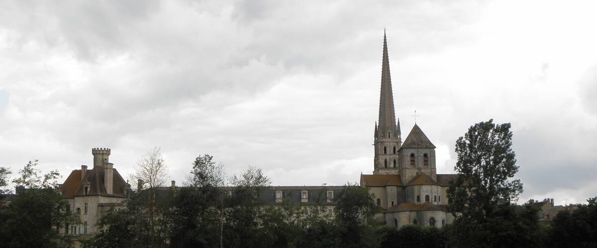 A historic church with a tall spire and a smaller adjacent building.
