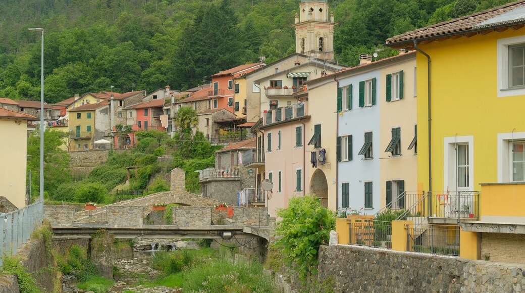 Un village perché sur une colline, avec des bâtiments aux couleurs vives, un pont de pierre et un clocher.
