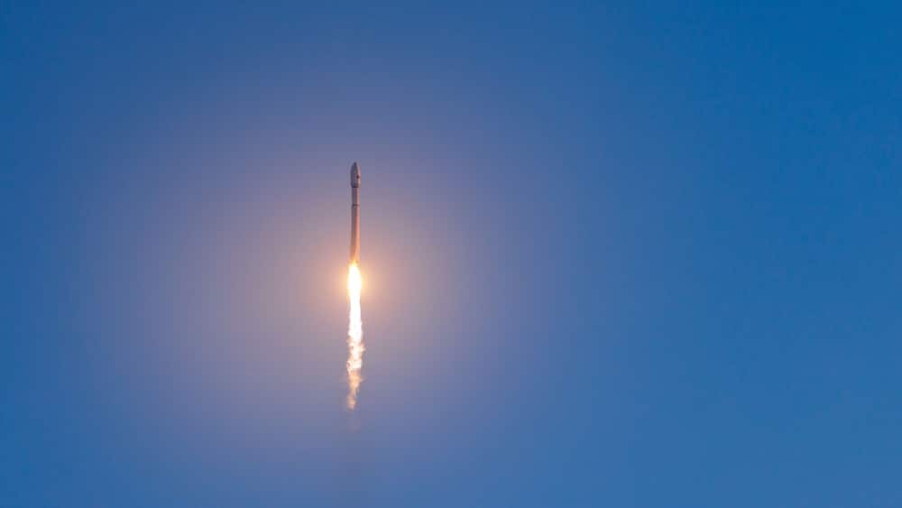Rocket with satellites launch against clear blue sky at daytime, banner of concept aerospace program