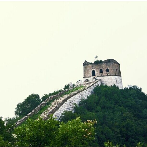 A stone tower on a hill with a staircase leading up to it.