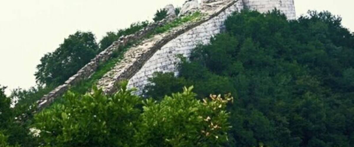 A stone tower on a hill with a staircase leading up to it.