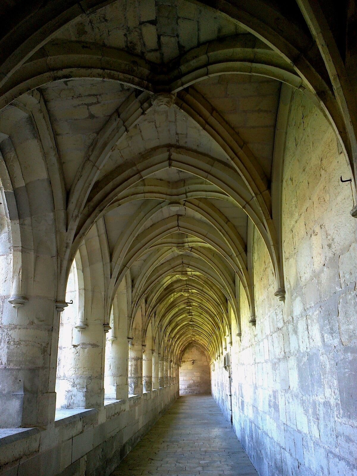 A long corridor with pointed arches and stone walls.