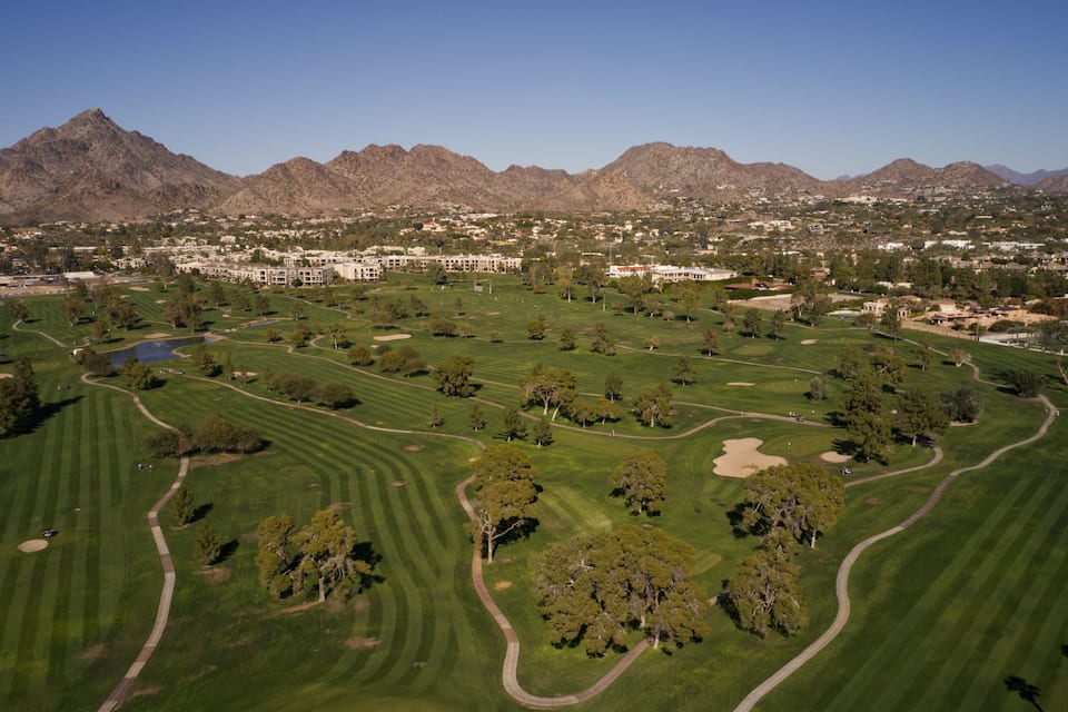 Um campo de golfe com uma cordilheira ao fundo.