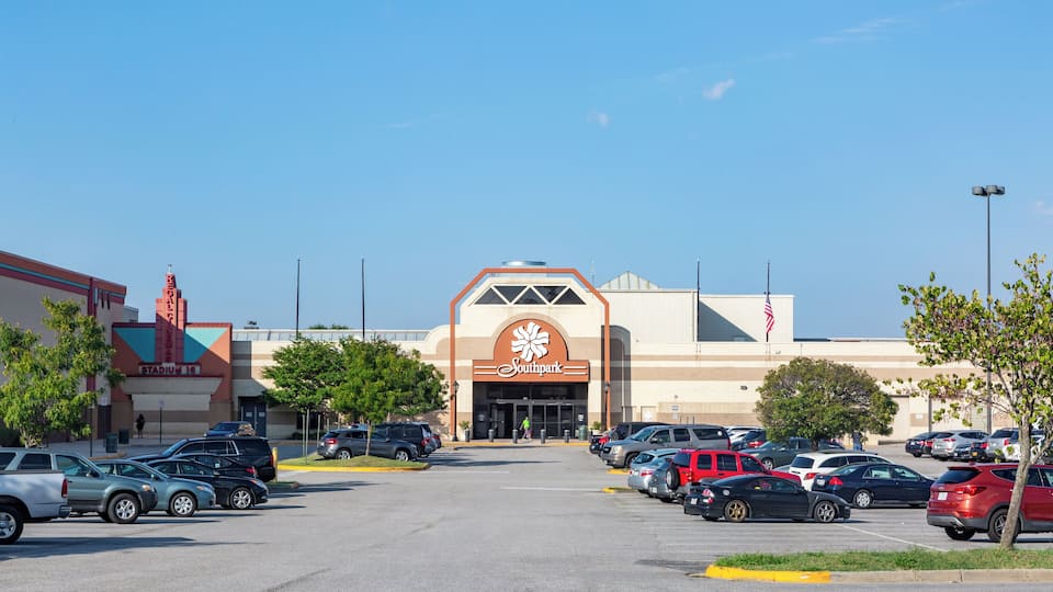 A parking lot with cars and a building with a large sign.