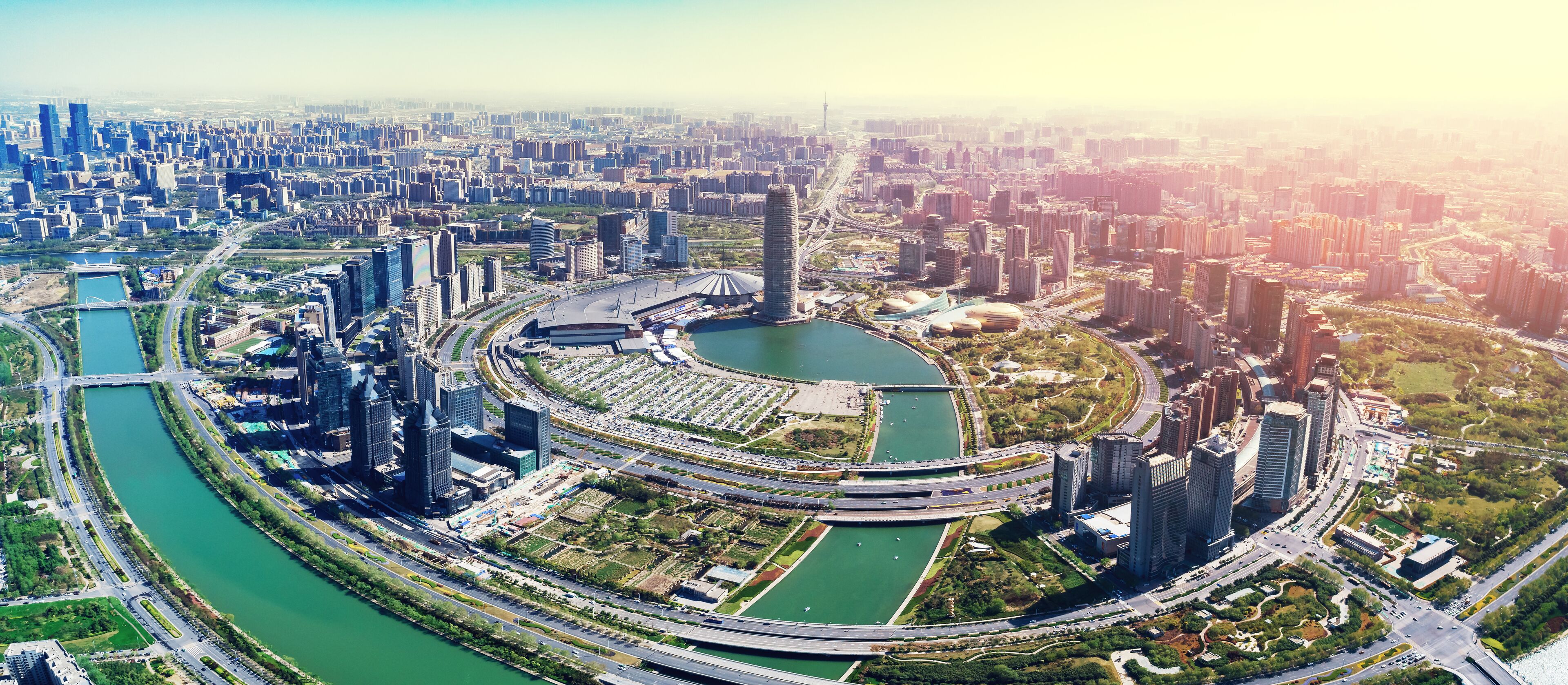 A cityscape with a river, high-rise buildings, and a distinctive circular structure.