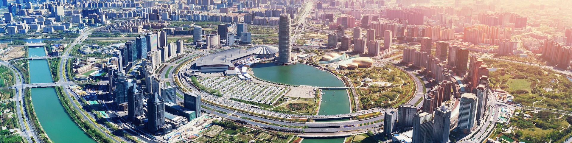 A cityscape with a river, high-rise buildings, and a distinctive circular structure.