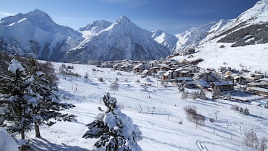 A snow-covered mountain village with ski slopes and buildings.