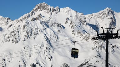 A snow-covered mountain with a cable car in the foreground.