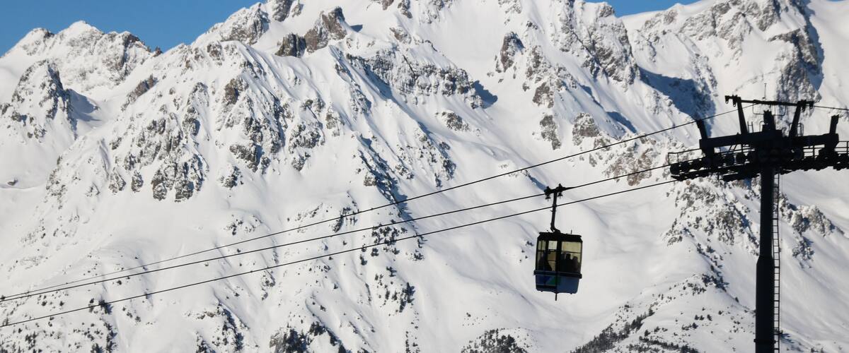 A snow-covered mountain with a cable car in the foreground.