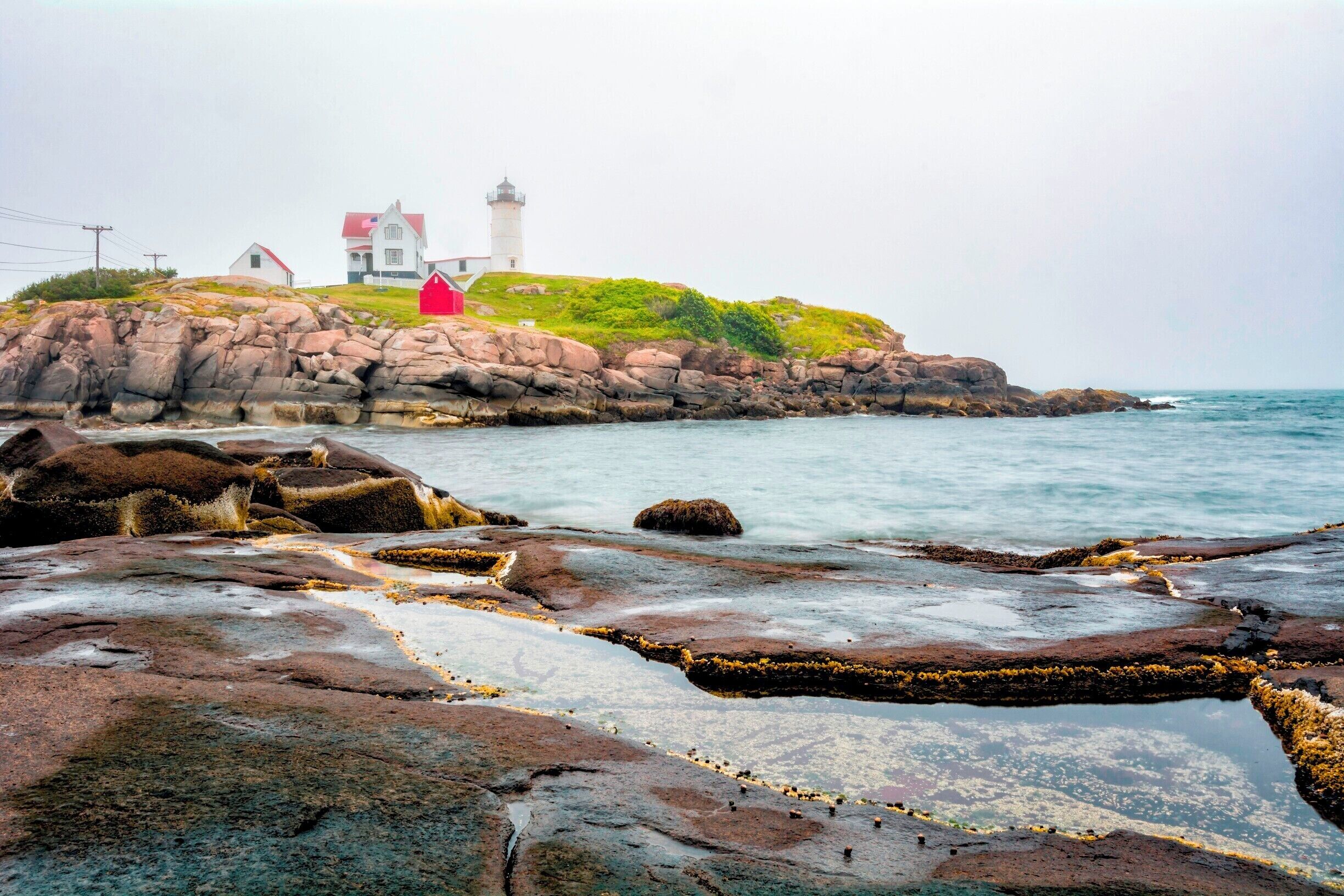 The Cape Neddick Light is a lighthouse in Cape Neddick, York, Maine. It was dedicated by the U.S. Lighthouse Service and put into use in 1879. It is still in use today. Considered to be one of the most photographed lighthouses, this 41-foot conical tower sits on the summit of Cape Neddick Bubble, a small offshore rocky islet, looking proudly over the Atlantic.
Accessibility: Follow Nubble Road east from Route 1A (Long Beach Ave.) in York, near Long Sands Beach, for about 1 mile to Sohier Park. There is free parking at Sohier Park with an excellent view of the lighthouse. The lighthouse and grounds are not open to the public.