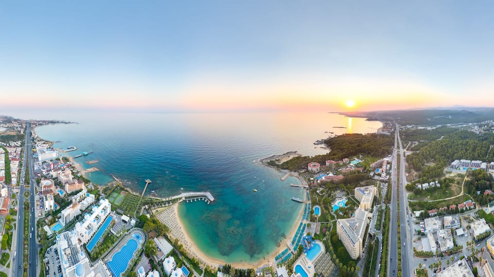 A coastal cityscape with a beach, marina, and residential areas.