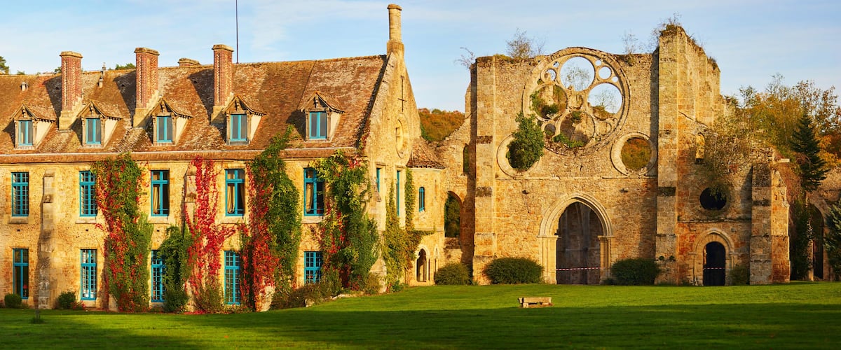 A historic building with ivy-covered walls and a large stone structure with circular windows.