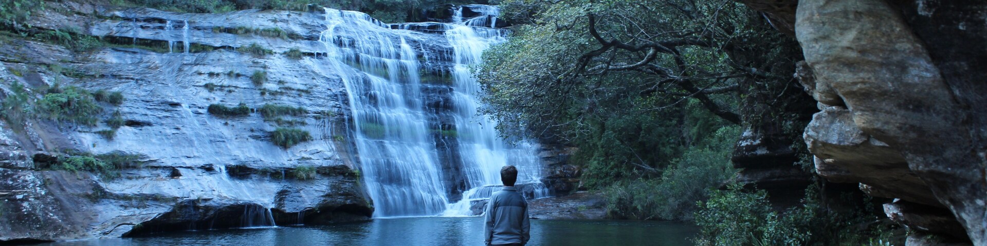 homem admirando Cachoeira do lago Azul em Jaguariaíva, Paraná, Brasil