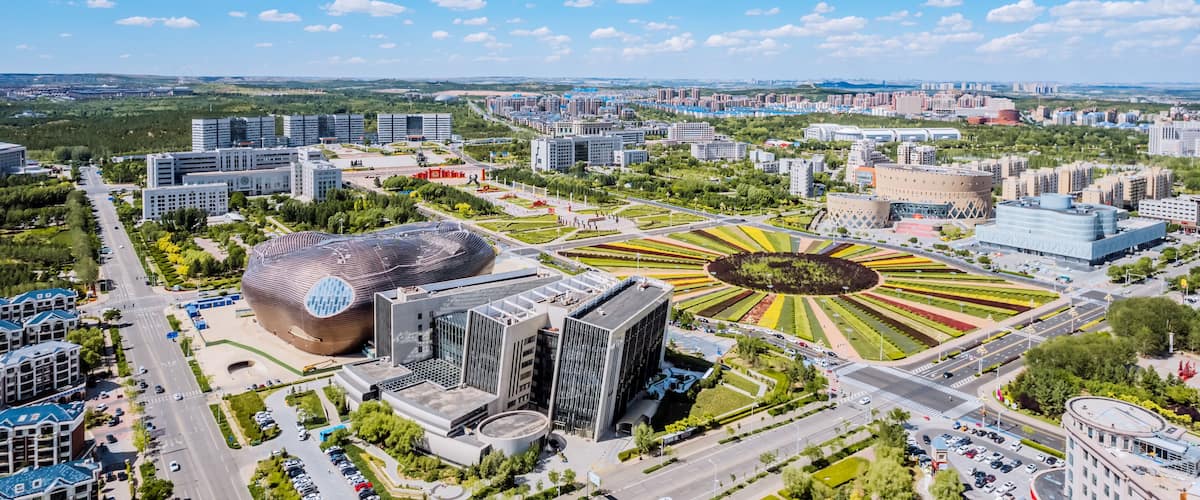 A cityscape with modern architecture, a distinctive circular park, and a large dome-shaped building.