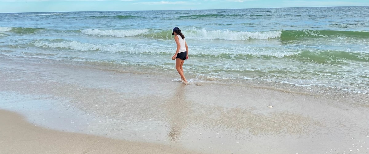 Rear shot of a girl having fun in the sandy Long Island beach, New York