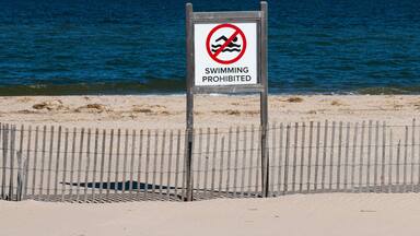 Swimming prohibited sign on empty beach