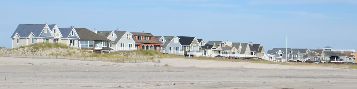 A beachfront with houses and dunes.
