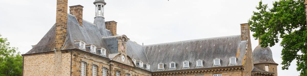 The castle of Flers, now a museum (Normandy, Orne, France). Beautiful medieval architecture. Wide-angle shot of this historical monument. Surrounded by a moat. Cloudy day.