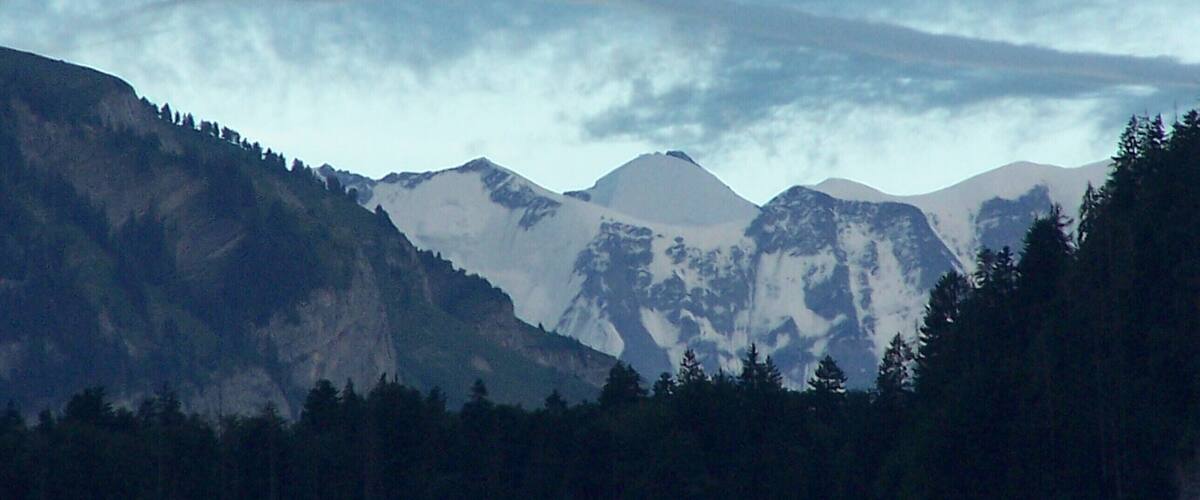 A mountain range with a cloud formation resembling a rainbow.