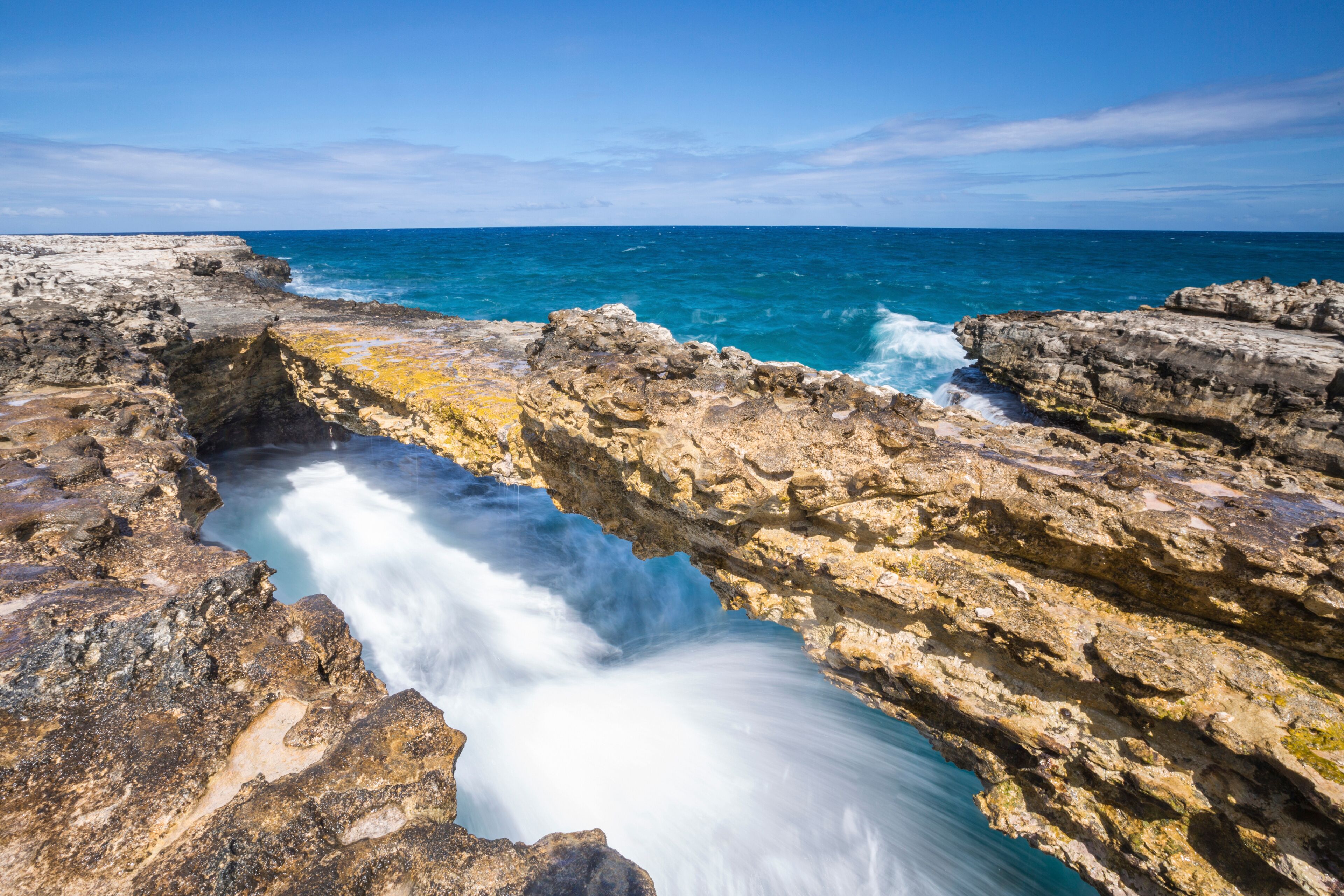 A coastal rock formation with a flowing water channel.