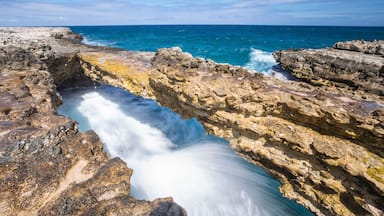 A coastal rock formation with a flowing water channel.