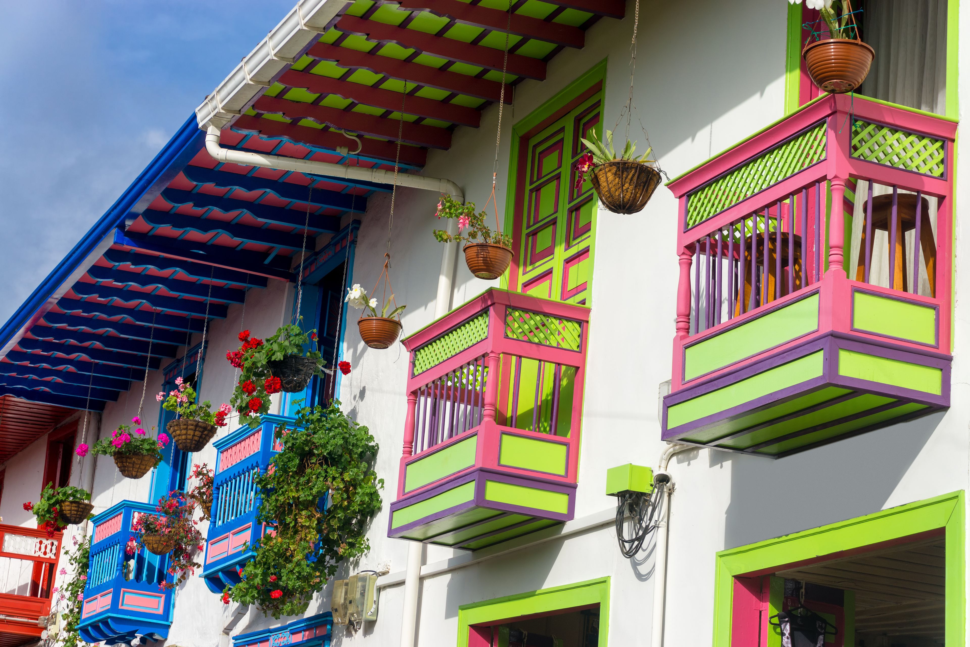 Un edificio colorato con balconi vivaci e cesti di fiori pensili.