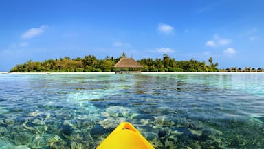 Sicht von einem Kanu auf Malediven Insel über türkises Meer und Korallen