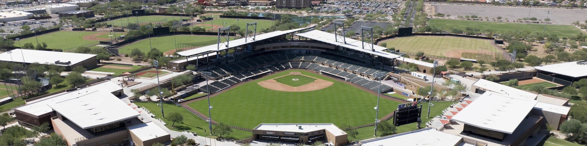 Aerial view of Salt River Fields at Talking Stick, a verdant baseball stadium nestled among the arid landscape, a striking contrast against the distant mountains, Scottsdale, Arizona, United States.